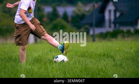 Kinder spielen im Freien in einem Park Fußball, konzeptionelle Kindheit, aktiver Lebensstil und Kopierraum Stockfoto