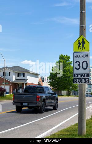 Schild, das die Geschwindigkeitsbegrenzung der Schulzone auf 30 km/h angibt. Stockfoto