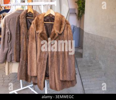 Sammlung von Vintage-Pelzmänteln, die an einem Kleiderständer auf einem Markt im Freien in Bukarest, Rumänien, hängen. Stockfoto