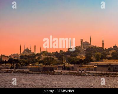 Istanbul, Türkei - 21. Juli 2024: Stadtansichten. Blaue Moscheen wie Sultan Ahmed und Hagia Sophia, die von rötlichem Sonnenaufgangslicht über dem Goldenen Horn umgeben sind Stockfoto