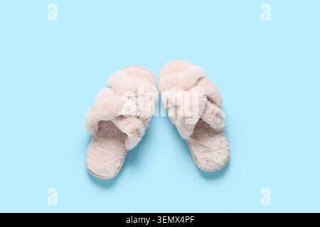 Weiche pinkfarbene Hausschuhe auf blauem Hintergrund Stockfoto