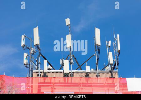 Hi-Tech-Mobilfunkantennen sind auf einem Dach in der Innenstadt zu sehen Stockfoto