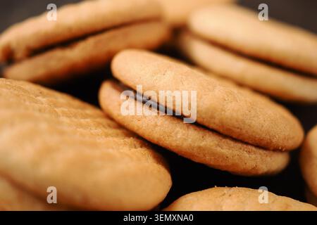 Kekse auf einer schwarzen Oberfläche mit Schokoladenfüllung Stockfoto