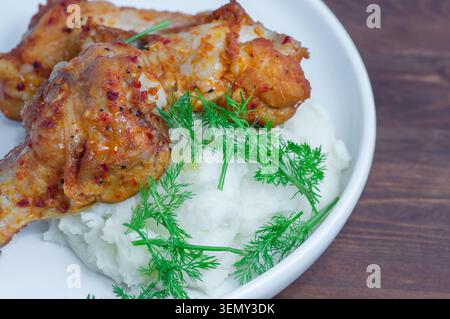 Gegrillte Hähnchenschenkelviertel und Kartoffelpüree mit Dill bestreut. Nahaufnahme. Stockfoto
