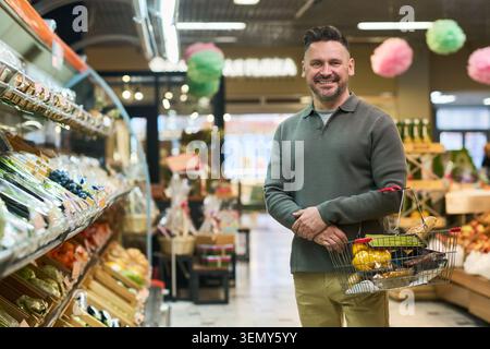 Porträt eines Erwachsenen, der Lebensmittel im Supermarkt kauft Stockfoto