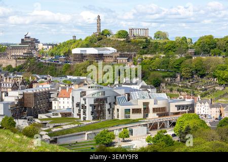 Das schottische Parlament mit Calton Hill im Hintergrund aus dem Holyrood Park, Edinburgh, Schottland Stockfoto