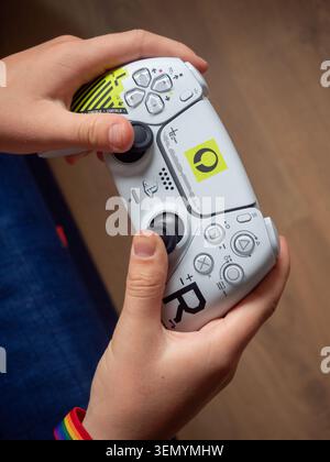 Sitges, Spanien - 06. Juni 2026: Eine redaktionelle Nahaufnahme einer Person, die Hände hält und mit einer klassischen PlayStation 5 du in weiß und Schwarz spielt Stockfoto