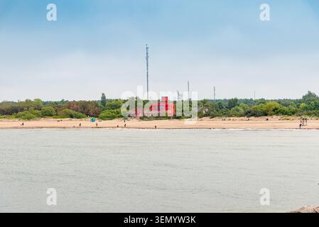 Breiter Sandstrand mit Meereswellen unter bewölktem Himmel. Malerische Ostseeküste mit einem Rettungsschirm-Turm an einem leeren Sandstrand. Klaipeda, Lithu Stockfoto