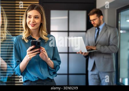 Junge glückliche, erfolgreiche Geschäftsfrau, die im Büro arbeitet Stockfoto