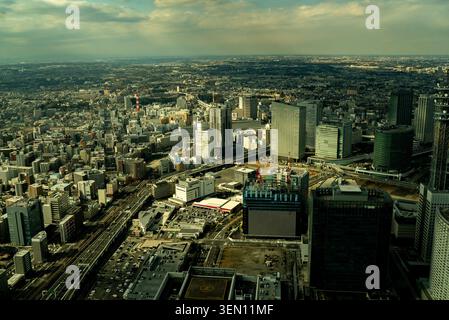 Hochwinkelblick aus der Luft auf eine dichte, moderne Skyline der Stadt und eine urbane Landschaft unter einem bewölkten Himmel Stockfoto