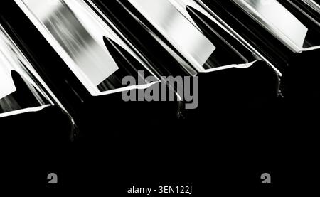 Nahaufnahme reflektierender Metallstrahlen in Schwarz-weiß zur Hervorhebung geometrischer Linien. Stockfoto