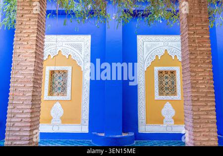 Nahaufnahme traditioneller marokkanischer Fenster und kunstvoller Bögen auf der berühmten blauen Mauer der Majorelle in Marrakesch, marokkanischer Garten Stockfoto
