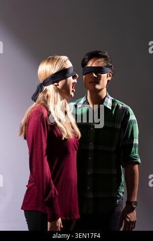 Katie und Kevin Tsang stehen eng zusammen in einem Studio. Beide sind mit den Augen verbunden und Katie bringt Überraschung zum Ausdruck. Stockfoto