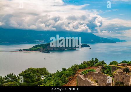 Blick auf die Insel St. Nikolaus in Budva, umgeben von der klaren Adria, mit den antiken Steinruinen der Festung Mogren Stockfoto