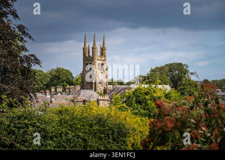 Breiter Blick auf die Landschaft mit Blick auf die historische Dachlinie des Dorfes Tideswell, eingebettet hinter grünen Hecken mit dem majestätischen Kirchturm Stockfoto