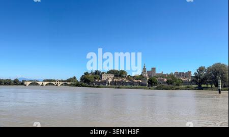 Blick über die Rhone auf die Pont Saint-Benezet, die berühmte Pont d Avignon und die Altstadt mit dem Papstpalast in Avignon, Frankreich. Stockfoto