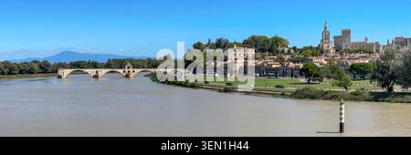 Blick über die Rhone auf die Pont Saint-Benezet, die berühmte Pont d Avignon und die Altstadt mit dem Papstpalast in Avignon, Frankreich. Stockfoto