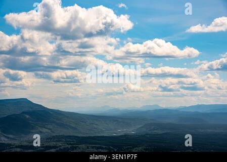 Dramatische Bergkette unter einem riesigen Himmel voller weicher weißer Wolken im Yukon Territory, Kanada. Stockfoto