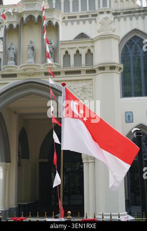 Singapur City, Singapur - 9. Juli 2025 - Eine festliche vertikale Nahaufnahme der rot-weißen Singapur Nationalflagge und dreieckigen hängenden Wa Stockfoto