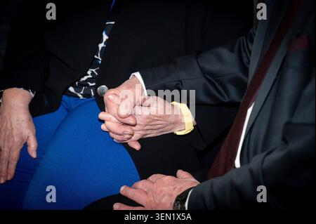 Ein älteres Paar, das die Hände zusammenhält. Eine Frau und ein Mann sitzen und halten die Hände fest zusammen. Stockfoto