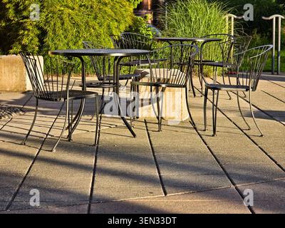 Sonnenterrasse mit Metallstühlen und Tischen Stockfoto