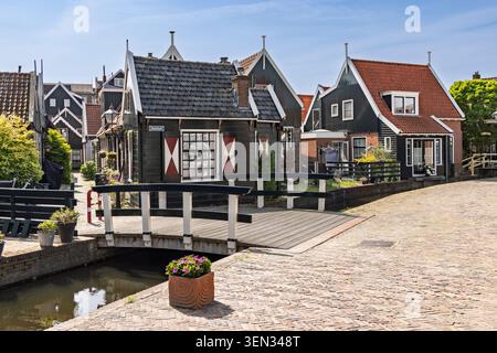Volendam, Niederlande. Malerischer Blick auf den historischen Doolhof mit traditionellen dunklen Holzhäusern mit roten und weißen Fensterläden. Stockfoto