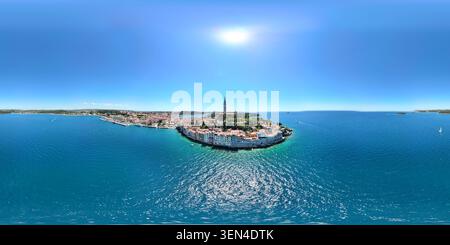 Ultraweites Luftpanorama über der Altstadt von Rovinj und der hellen Adria mit sonnendurchflutetem Wasser und klarem blauen Himmel. Stockfoto