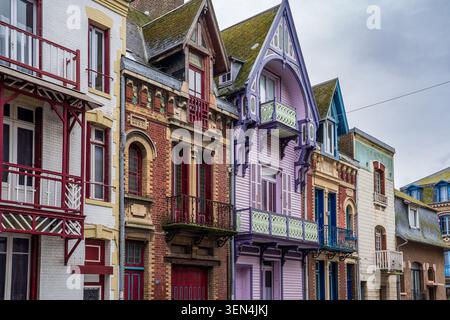 Perspektivische Sicht auf charakteristische Vintage-Villen in Mers-les-Bains. Das Foto zeigt verzierte Fassaden, darunter rote Backsteinwände, lila Holzstr Stockfoto