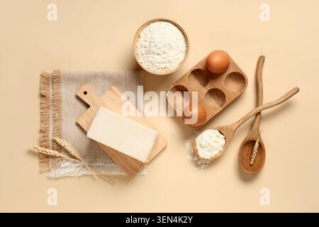 Backzutaten flach mit Mehl, Eiern, Teig und Weizen auf beigefarbenem Hintergrund für kulinarische Projekte Stockfoto