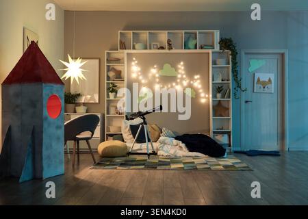 Gemütliches Kinderzimmer mit Teleskop, Raketenspielzelt und Sternenhimmel für fantasievolles Spielen und Lernen Stockfoto