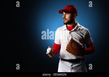 Professioneller Baseballspieler in roter Kappe und weißer Uniform, der Ball und Handschuh hält, bereit für Spielspaß Stockfoto