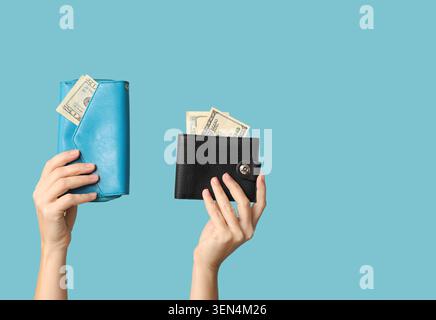 Hände mit blauen und schwarzen Geldbörsen mit US-Dollar-Scheinen, Finanzmanagement und persönlichem Finanzkonzept, zwei Hände halten eine blaue Geldbörse mit einem Twinn Stockfoto