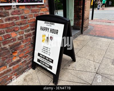 Manchester, Großbritannien - 07. Mai 2026: Sandwichbrett auf dem Bürgersteig, das Happy Hour-Drinks und Studentenangebote vor der Bar Joshua Brooks in Manchester, Großbritannien, anbietet. Stockfoto