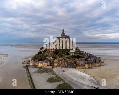Hochwinkelansicht der befestigten Insel Mont-Saint-Michel aus der Vogelperspektive. Das Foto zeigt die mittelalterliche Abtei auf dem Gipfel, Steinmauern mit Dorfhäusern, Stockfoto