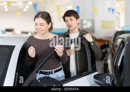Junge in einem Autohändler wählt ein Auto Stockfoto