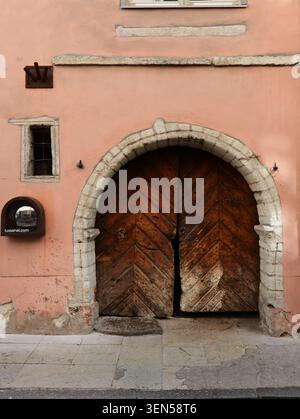 Eine gotische Holztür mit einem rustikalen Steinbogen in einem alten Gebäude in der Altstadt von Tallinn, Estland. Stockfoto