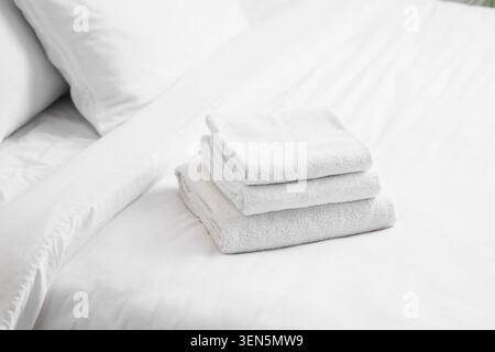 Saubere weiße Handtücher auf frischen Betten, Hotelgastfreundschaft und Spa-Komfort, minimalistische Wohnkultur und Hygiene Stockfoto