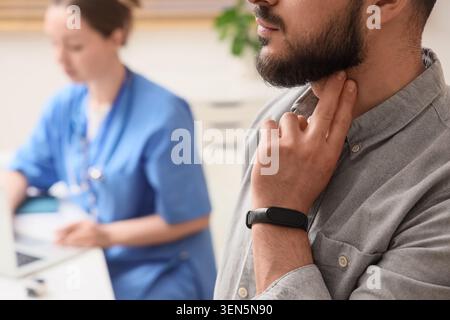 Mann, der den Carotispuls mit Fitness-Tracker überprüft, medizinische und medizinische Untersuchung, Patientengesundheitsüberwachung Stockfoto