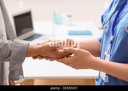 Medizinischer Fachmann hält die Hand des Patienten, Unterstützung und Mitgefühl im Gesundheitswesen, Arzt-Patient-Vertrauen und Empathie Stockfoto