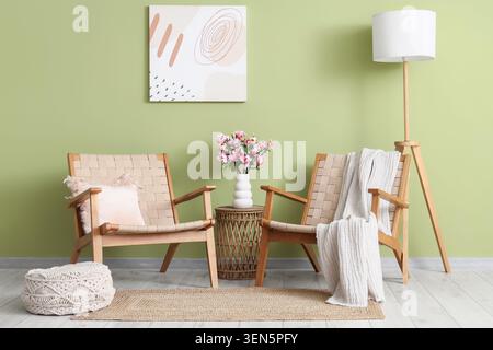 Gemütliches Wohnzimmer mit modernen Holzsesseln, Stehlampe und abstrakter Wandkunst Stockfoto