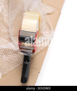 Verpackungsband-Spender mit Luftpolsterfolie und Karton für Versand- und Umzugsservices, dieses Setup unterstreicht den Prozess der Sicherung von Artikeln für Stockfoto