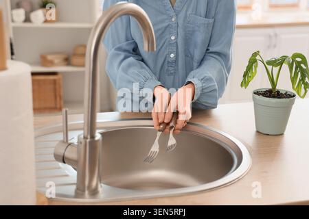 Frauenhände waschen Gabeln in Küchenspüle, tägliche Arbeiten und Hauspflege, Sauberkeit und Hygiene Stockfoto