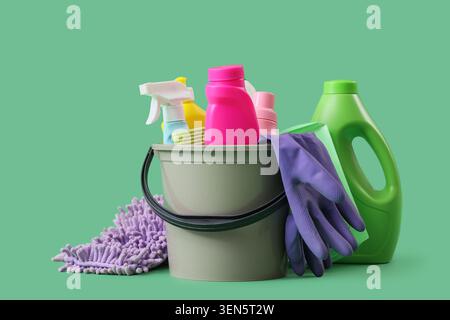 Haushaltsreinigungseimer mit bunten Reinigungsmitteln, Sprays, Handschuhen und Mopp für die Hausreinigung Stockfoto