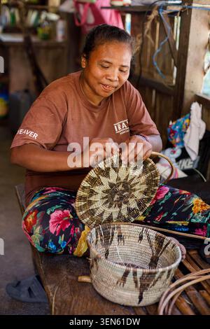 Ein Mangyan webt in einer Dorfwerkstatt auf Mindoro Island, Philippinen, einen traditionellen Korb von Hand und zeigt täglich indigene Handwerkskunst Stockfoto