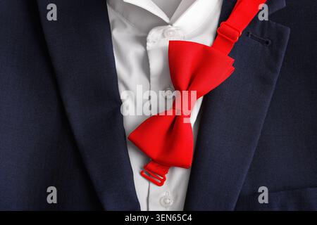 Rote Schleife auf weißem Hemd und marineblauer Anzugsjacke, formelle Kleidung und Business-Kleidung für besondere Anlässe Stockfoto