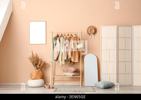 Moderne, minimalistische Ankleidezimmer mit Kleiderständer, Ganzkörperspiegel und dekorativen Elementen Stockfoto