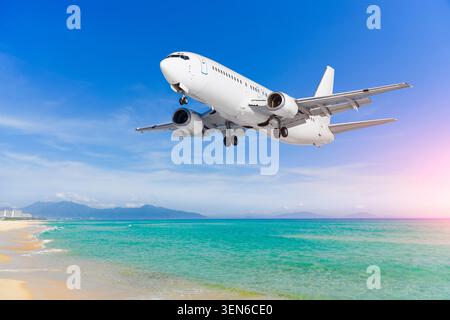 Flugzeugjet fliegt über tropischen Strand an der Meeresküste, Ankunft am Resort Flughafen. Stockfoto