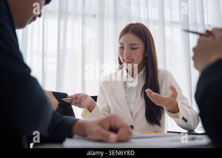 Asiatische Geschäftsfrau, die ein gemeinsames Meeting mit Kollegen in modernen Gesprächen über die Zusammenarbeit im Büro leitet Stockfoto