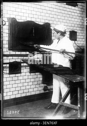 Eine Bäckerin arbeitet 1919 in einem Brotbackofen. Das Pressefoto dokumentiert die Beschäftigung von Frauen im Backgewerbe und dokumentiert die Tätigkeit der Bäckerei in Frankreich während der Nachkriegszeit. Stockfoto
