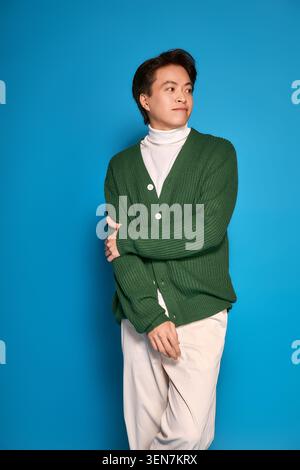 Der junge asiatische Mann zeigt ein einzigartiges Outfit in einem hellen Studio, das seinen persönlichen Stil ausdrückt Stockfoto